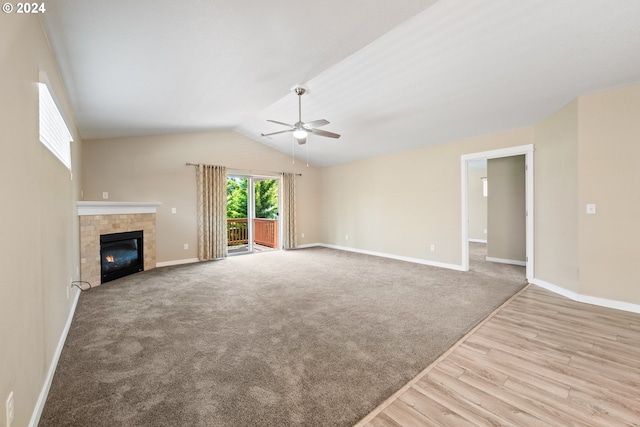 unfurnished living room featuring ceiling fan, a fireplace, lofted ceiling, and light hardwood / wood-style flooring