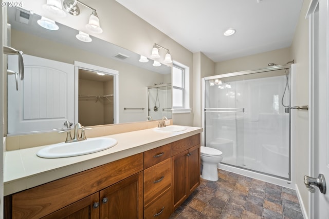 bathroom featuring vanity, toilet, and an enclosed shower