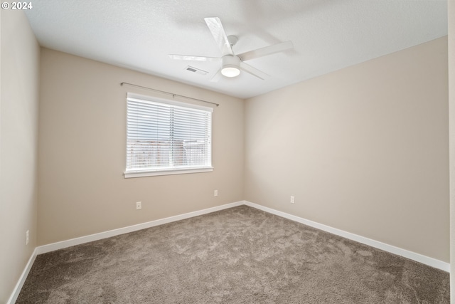 empty room featuring a textured ceiling, light colored carpet, and ceiling fan