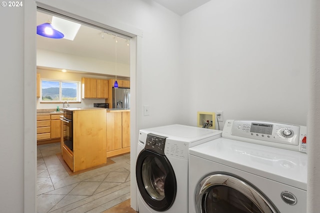 laundry room featuring light tile patterned floors, laundry area, and washer and clothes dryer