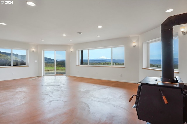 spare room with concrete floors, a mountain view, baseboards, and recessed lighting