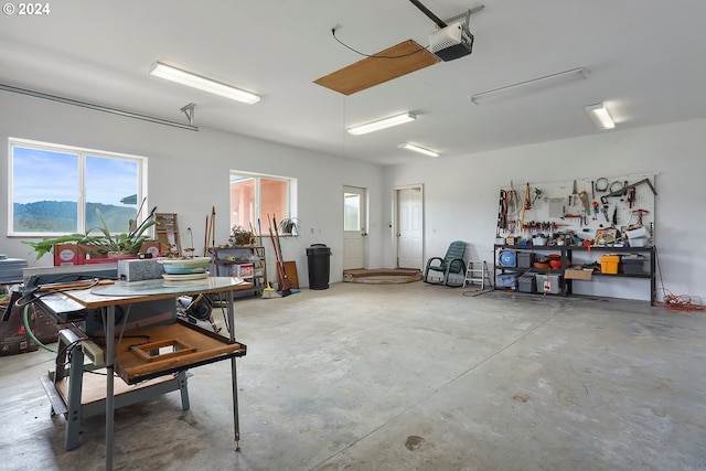 garage with a garage door opener, a mountain view, and a workshop area