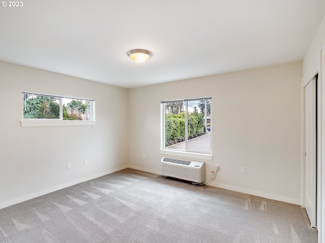 carpeted spare room featuring a wall mounted AC