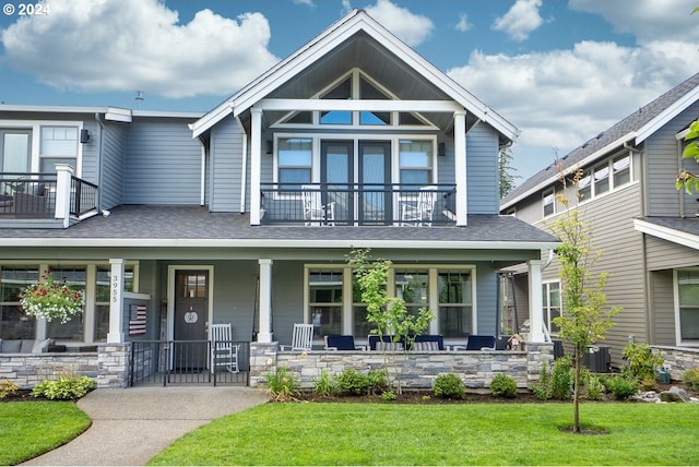 craftsman inspired home with a balcony, a porch, and a front lawn