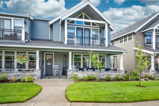 craftsman house featuring a balcony, a porch, and a front yard