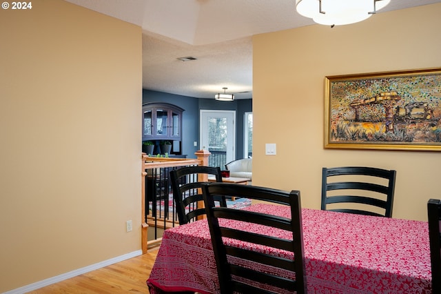 dining space with light hardwood / wood-style flooring and a textured ceiling