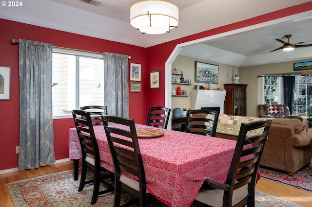 dining space with a textured ceiling, light wood-type flooring, and ceiling fan