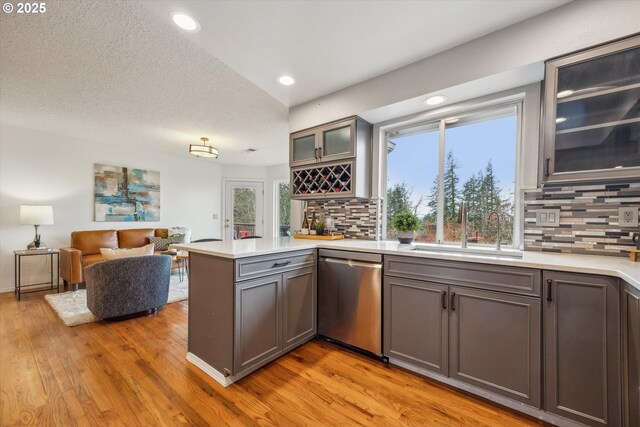 kitchen with gray cabinetry, wall chimney exhaust hood, sink, and appliances with stainless steel finishes