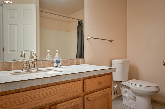 bathroom with tile patterned flooring, vanity, toilet, and walk in shower