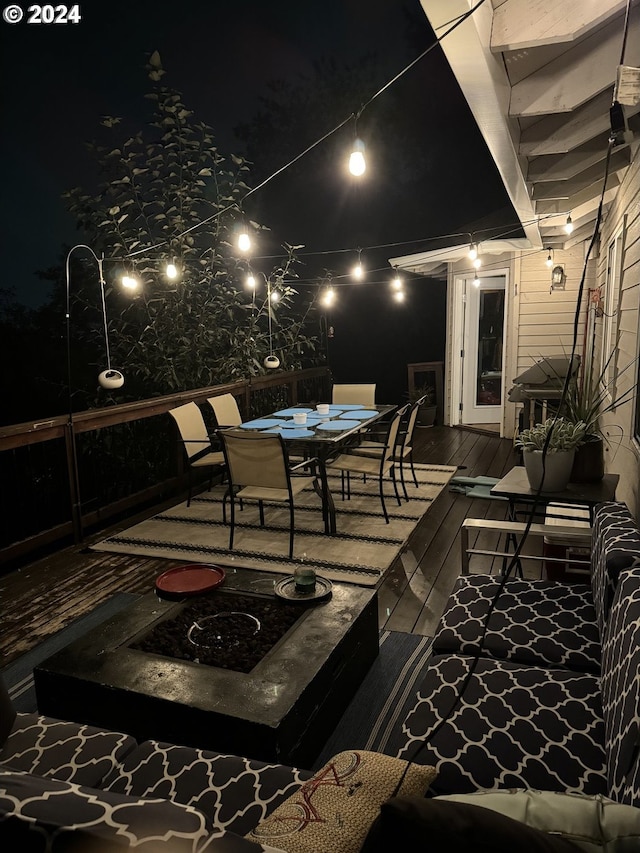 patio at night featuring a deck