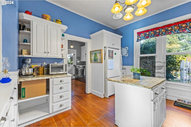 kitchen with white cabinets, a kitchen island, light hardwood / wood-style flooring, white fridge, and washer and clothes dryer