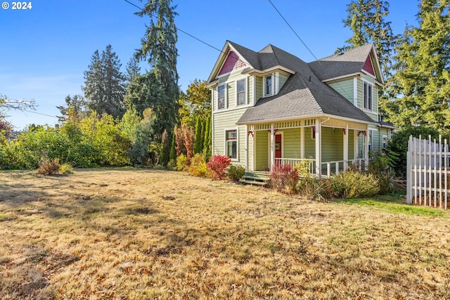 view of side of home featuring a lawn and a porch