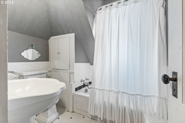 bathroom featuring lofted ceiling, shower / bath combination with curtain, tile walls, sink, and tile patterned floors