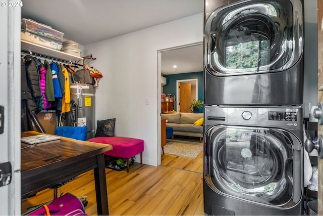 laundry area with water heater, stacked washer / dryer, and light hardwood / wood-style flooring