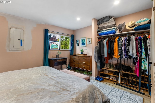 bedroom featuring hardwood / wood-style floors, electric panel, and a closet