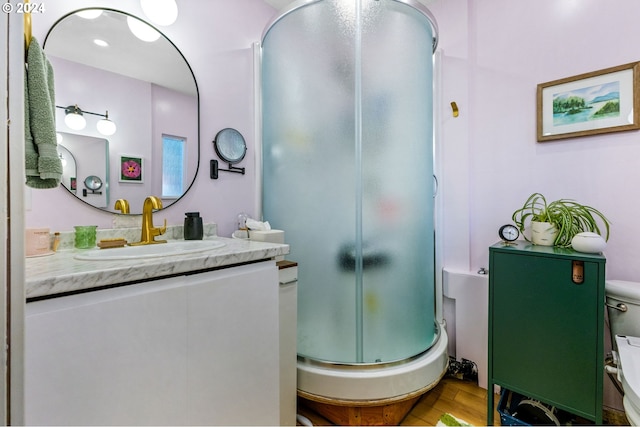 bathroom featuring vanity, wood-type flooring, toilet, and walk in shower