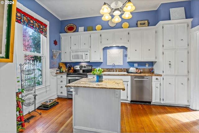 kitchen with white cabinetry, a healthy amount of sunlight, appliances with stainless steel finishes, and light hardwood / wood-style flooring