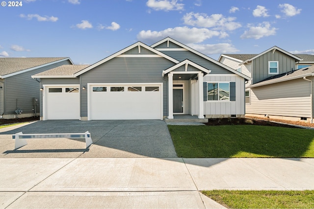 view of front facade featuring board and batten siding, a front yard, concrete driveway, and an attached garage