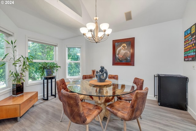 dining room featuring lofted ceiling, light wood-type flooring, visible vents, and a chandelier