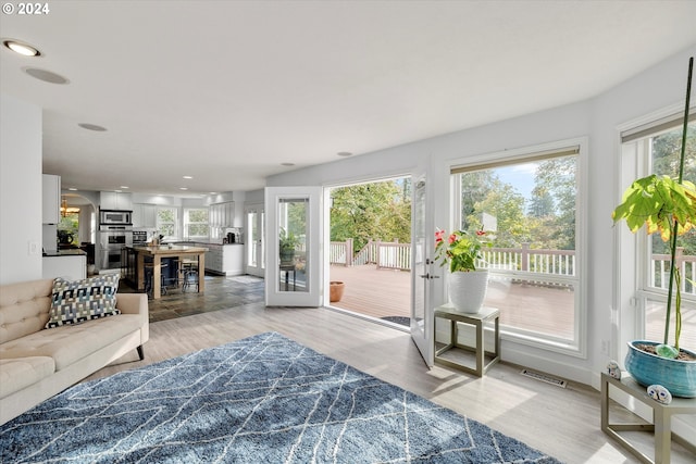 living area featuring light wood-type flooring, visible vents, and recessed lighting