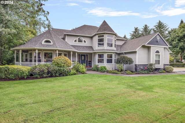 victorian house with a front yard and a porch