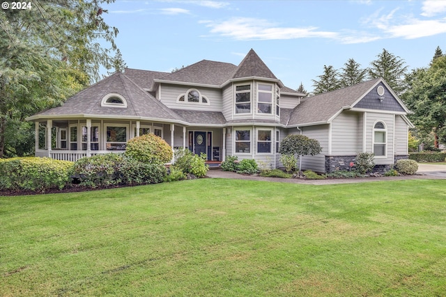 victorian home featuring a front yard and roof with shingles