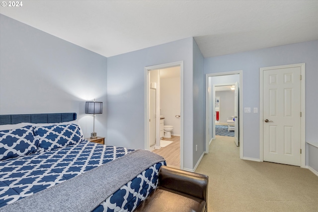 bedroom with connected bathroom, baseboards, and carpet flooring