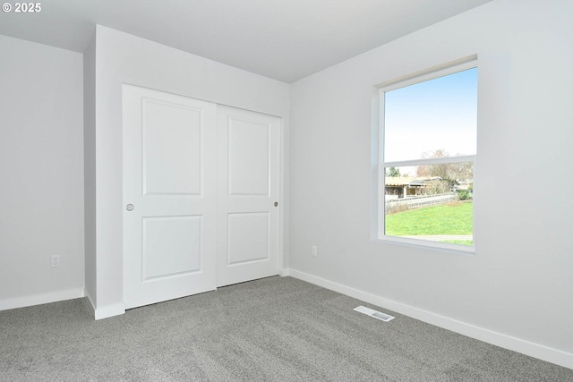 unfurnished bedroom with carpet floors and a closet