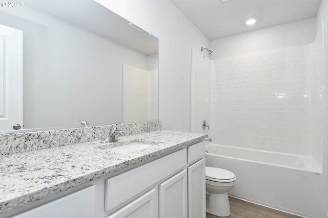 full bathroom featuring hardwood / wood-style flooring, toilet, vanity, and shower / bathtub combination