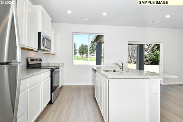 kitchen featuring sink, stainless steel appliances, a kitchen island with sink, white cabinets, and light wood-type flooring