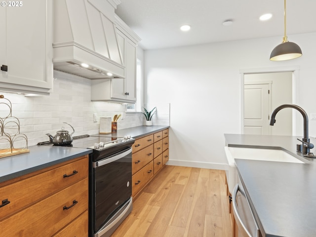 kitchen with custom exhaust hood, white cabinetry, decorative light fixtures, stainless steel appliances, and decorative backsplash