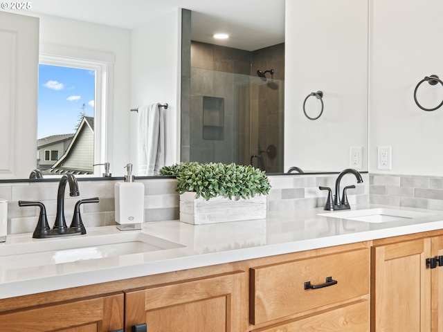 bathroom featuring vanity, decorative backsplash, and a shower with shower door