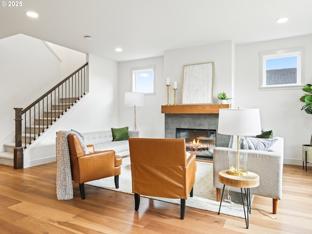 living area with a tile fireplace and light hardwood / wood-style flooring