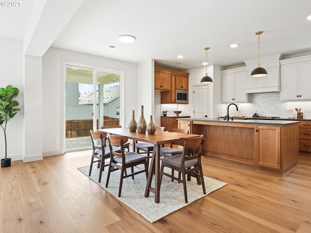 dining area featuring sink and light wood-type flooring