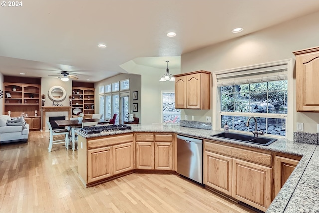 kitchen with sink, hanging light fixtures, kitchen peninsula, built in features, and stainless steel appliances