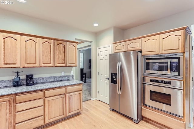 kitchen featuring stainless steel appliances, light hardwood / wood-style flooring, and light brown cabinets