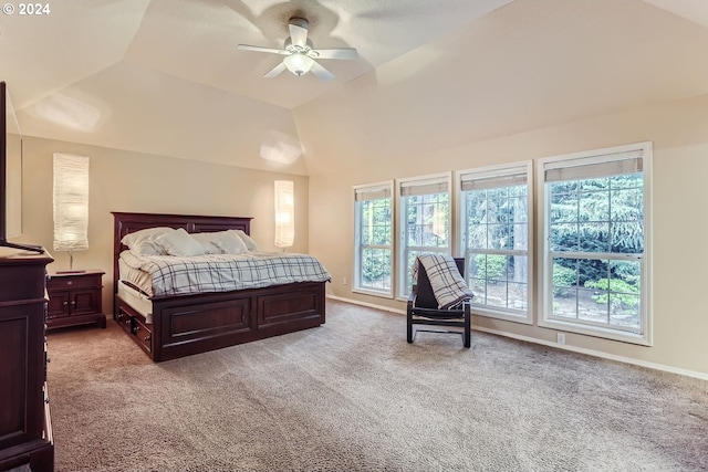 bedroom with ceiling fan, lofted ceiling, a tray ceiling, and light colored carpet