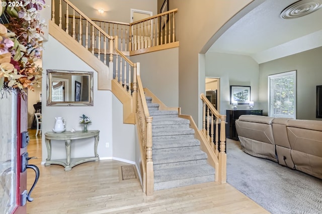 stairway featuring lofted ceiling and hardwood / wood-style flooring