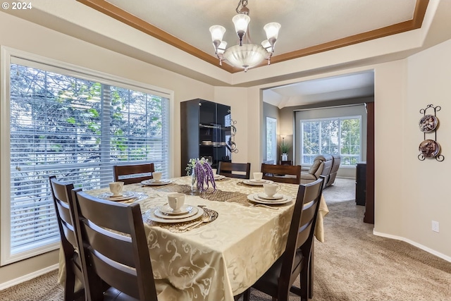 carpeted dining room with a raised ceiling and an inviting chandelier