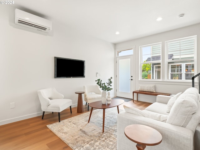 living room with light wood finished floors, recessed lighting, baseboards, and a wall mounted air conditioner