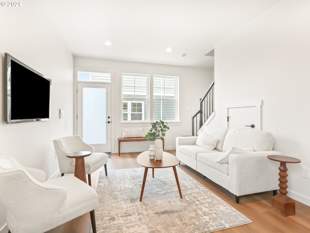 living area with recessed lighting, stairway, baseboards, and wood finished floors