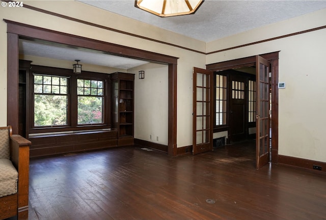 spare room with dark wood-type flooring, a textured ceiling, and french doors