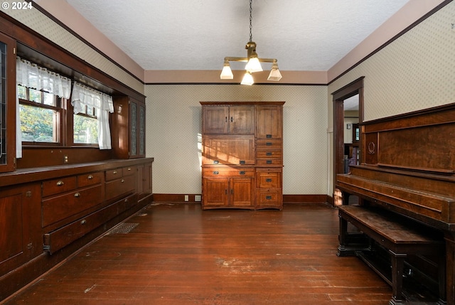 misc room featuring dark wood-type flooring, a textured ceiling, and an inviting chandelier