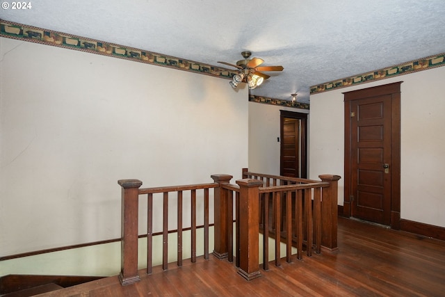 hall featuring dark wood-type flooring and a textured ceiling