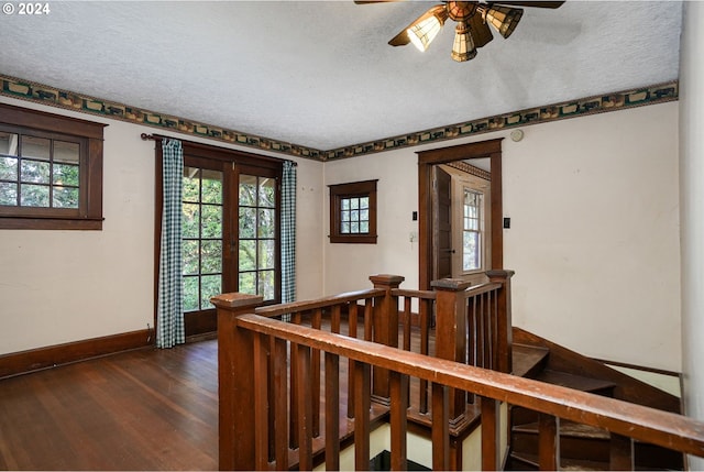 staircase featuring a textured ceiling, hardwood / wood-style flooring, ceiling fan, and french doors