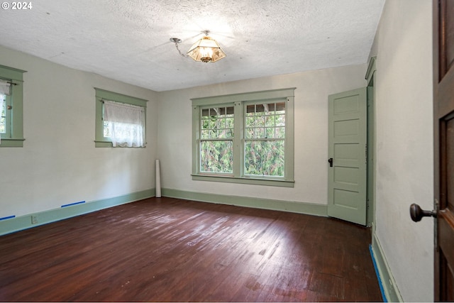 spare room with dark wood-type flooring and a textured ceiling