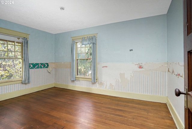 spare room with hardwood / wood-style floors and a textured ceiling