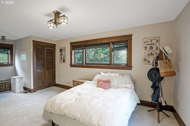 bedroom with light colored carpet and a closet