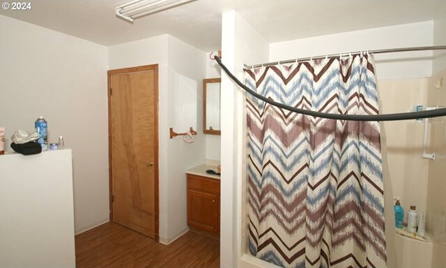 bathroom with wood finished floors and curtained shower
