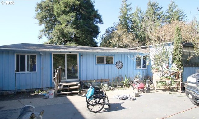 rear view of property featuring a patio and board and batten siding